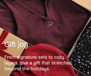 Maroon tank with a BY lotus, gift box, and red fabric in a box with text 'Gift joy.