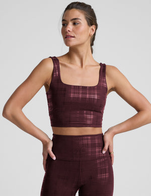 model wearing a red plaid foil printed square neck cropped tank top and matching leggings against a plain background. 