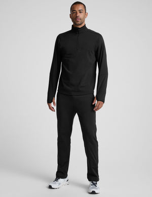 person wearing black pants and white sneakers on a light gray background