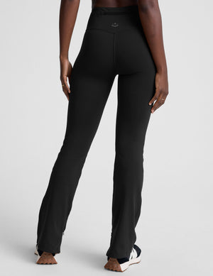 person wearing black high-waisted pants on a white background. 