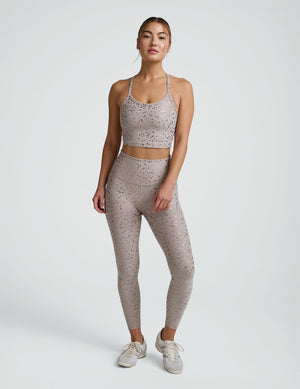 woman in pink mini moon printed cropped tank and leggings against a plain background. 