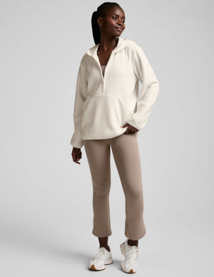 white fleece quarter zip jacket with a kangaroo pocket. 