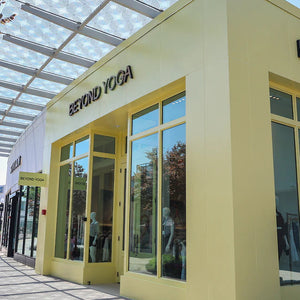 Yellow Beyond Yoga store front with large glass windows. 