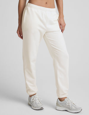 woman wearing white fleece sweatpants against a plain background. 
