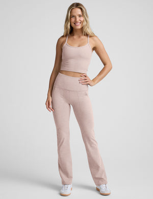 pink slim racerback cropped tank top and pink high-waisted midi leggings on a plain background. 