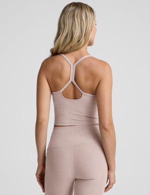 pink slim racerback cropped tank top and pink high-waisted midi leggings on a plain background. 