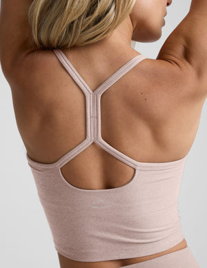 pink slim racerback cropped tank top and pink high-waisted midi leggings on a plain background. 