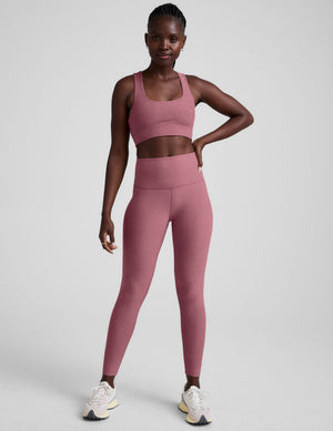 model is wearing a pink scoop neck racerback long line bra. 