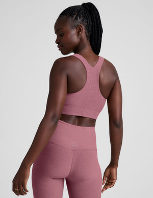 model is wearing a pink scoop neck racerback long line bra. 