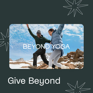 Two people practicing yoga on a snowy landscape with 'Beyond Yoga' branding.