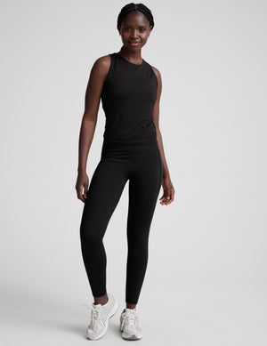 model wearing a scoop high neck racerback tank top against a plain background. 